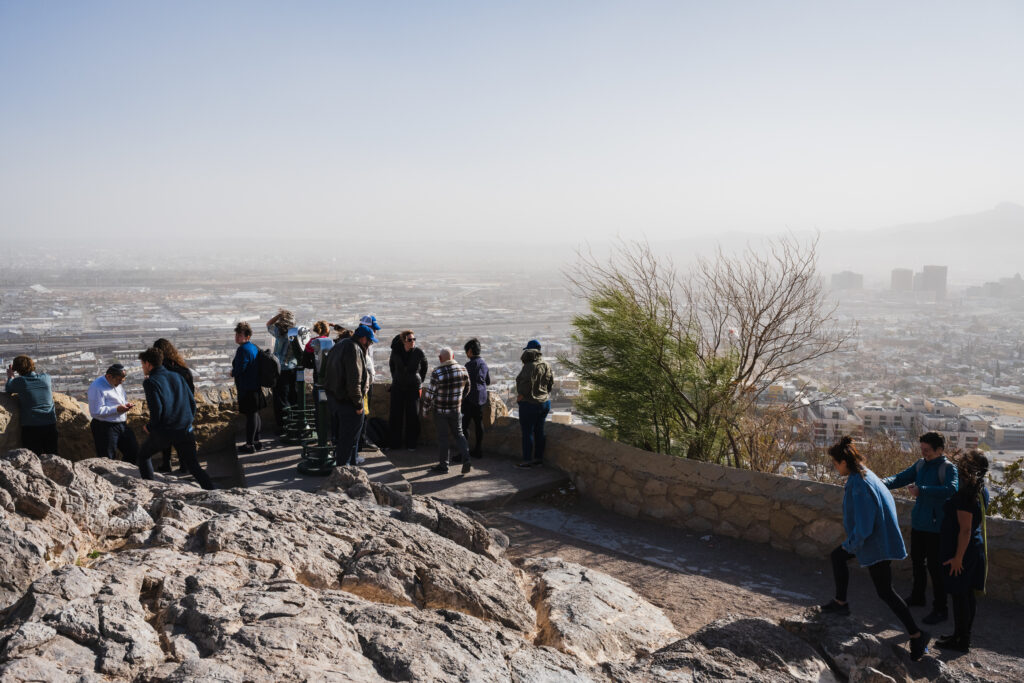 People standing on a border overlooking Mexico