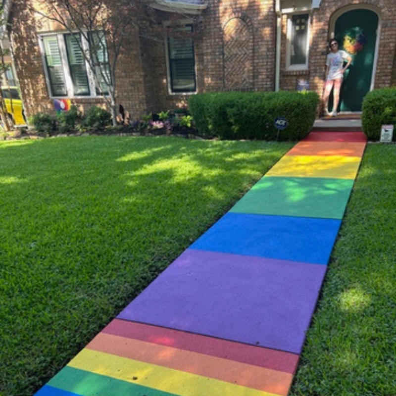 Photo of the author outside her home with her rainbow walkway.